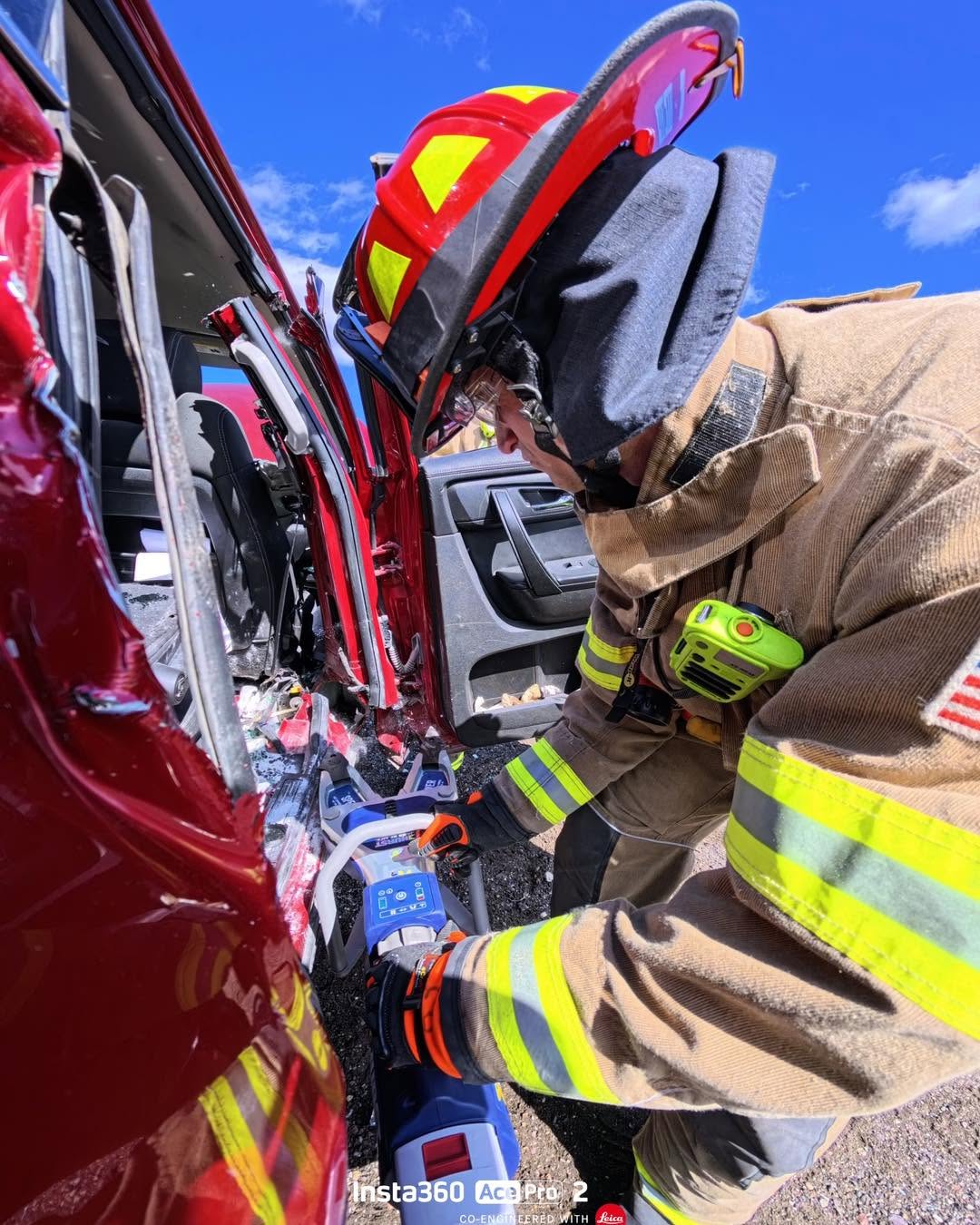Firefighter using hydraulic rescue tools during an extrication drill.