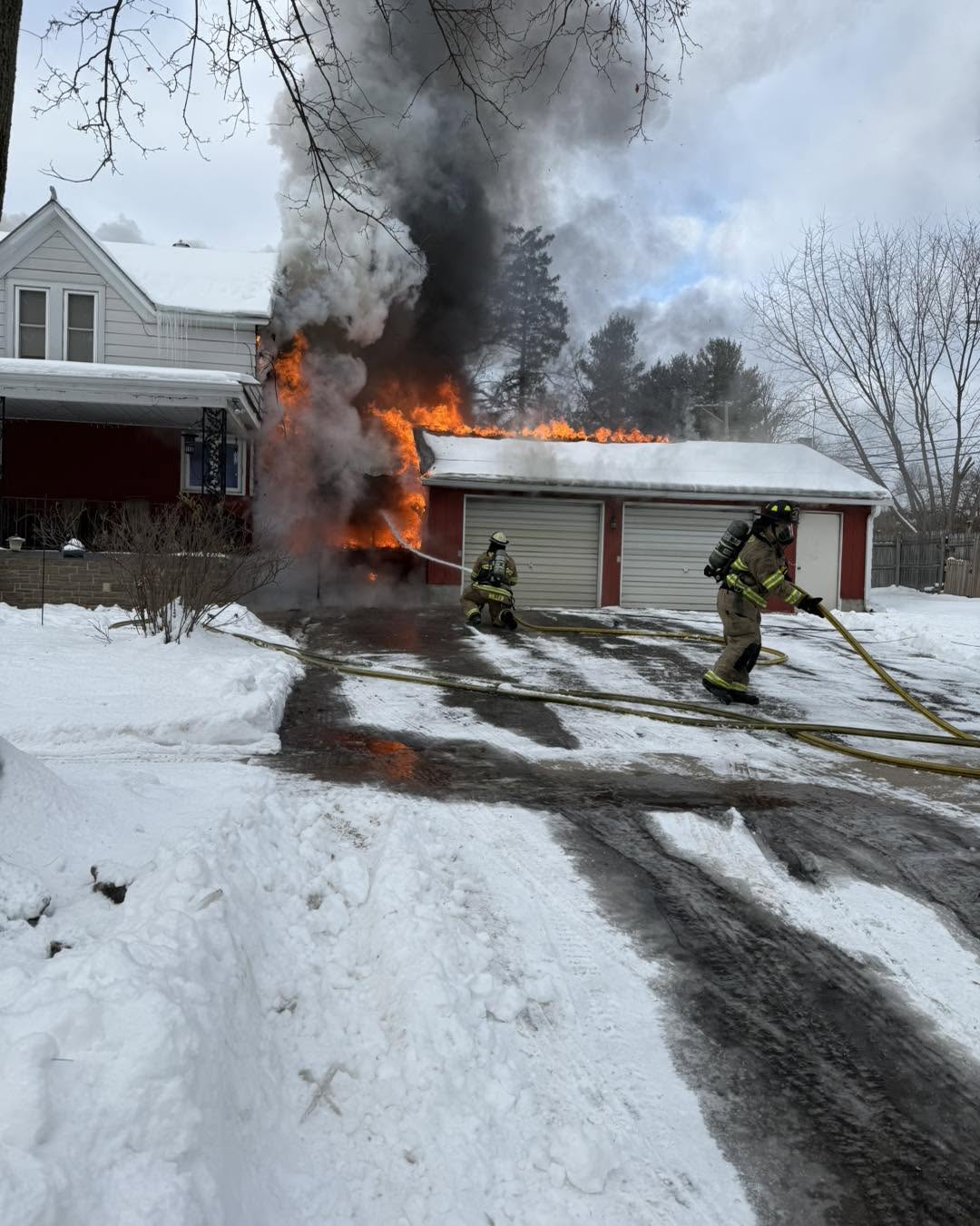 Firefighters operating at a house fire in winter conditions.