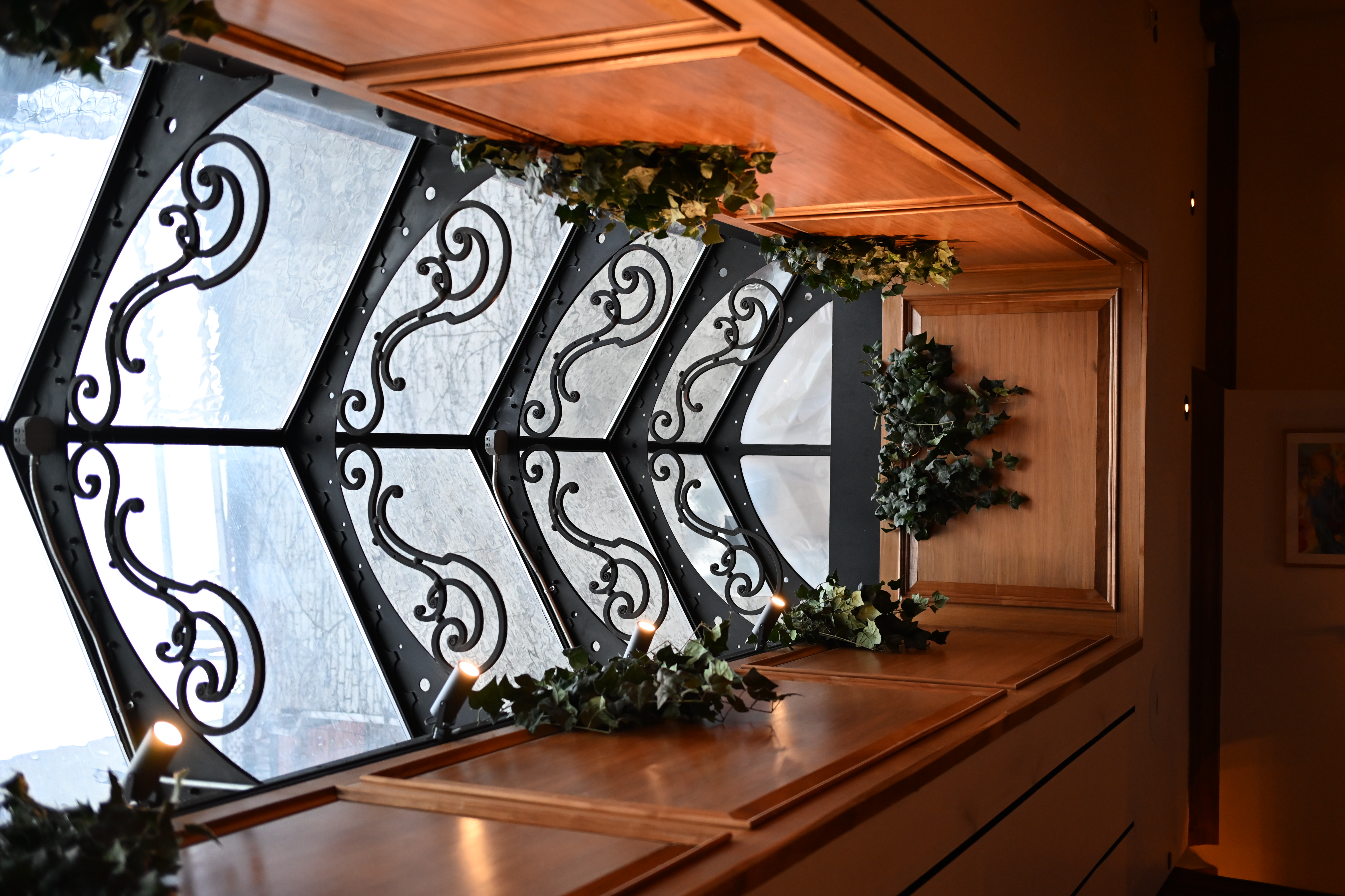 Wrought-iron bay window with greenery in the art deco space at Society Cafe