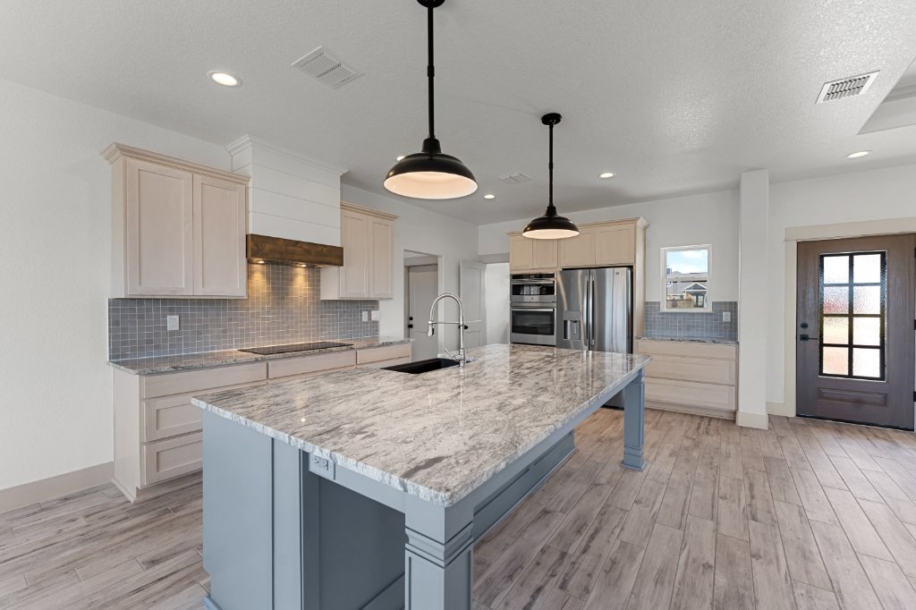 Blue-gray kitchen island with marble countertop by CJ Cabinets in San Antonio