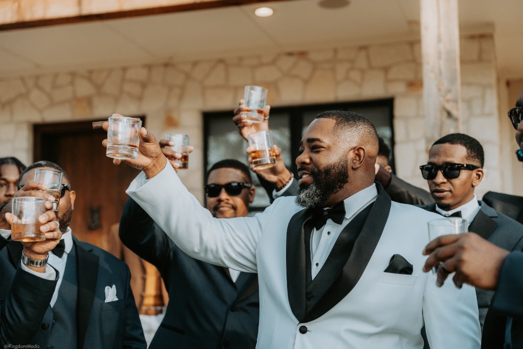 Groomsmen toasting with whiskey glasses