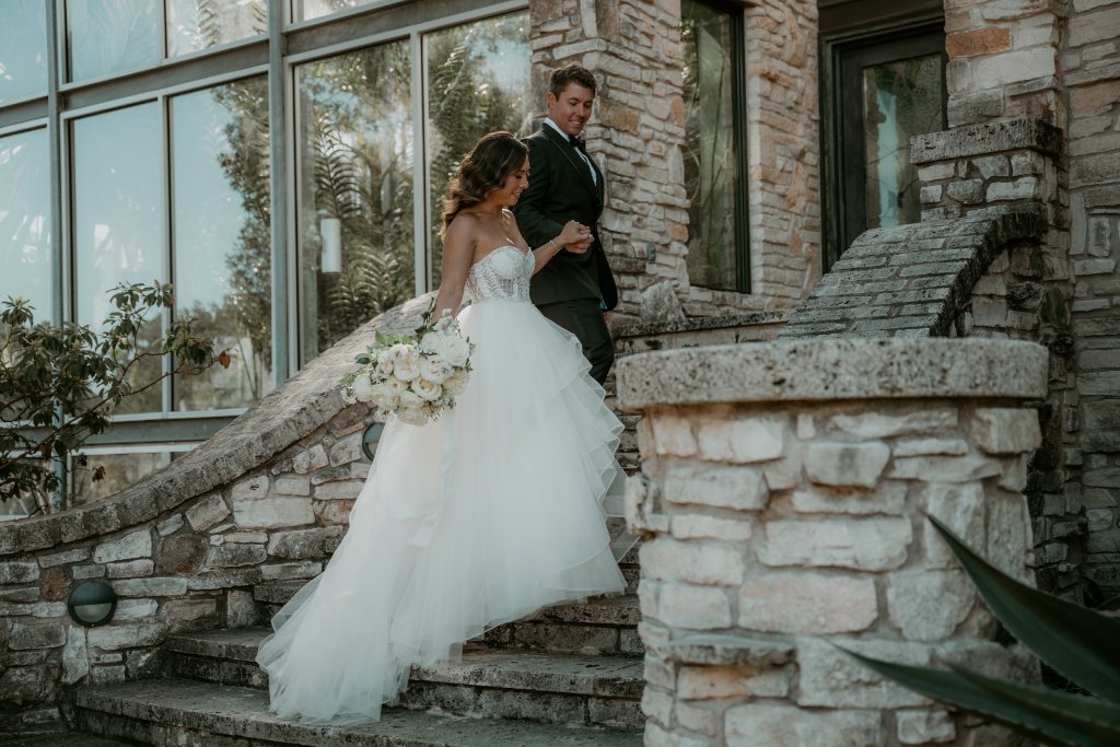 Bride and groom walking up stone steps