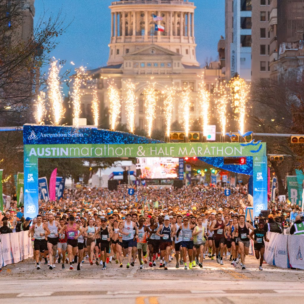 Start line with thousands of runners at dawn with Capitol building