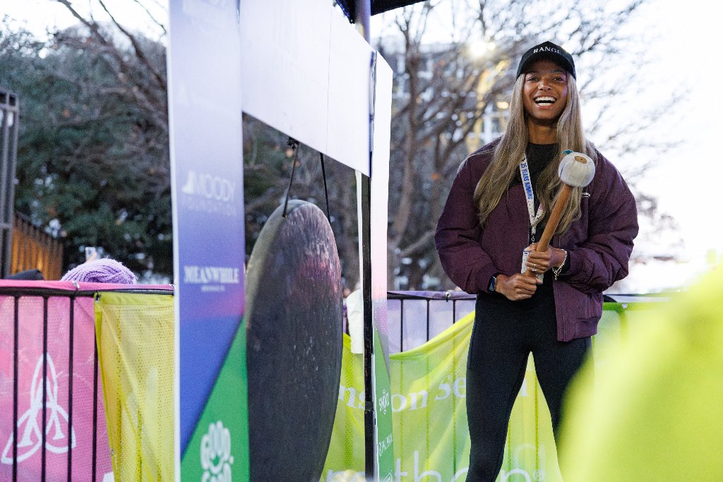 Woman hitting the PR gong at the finish festival