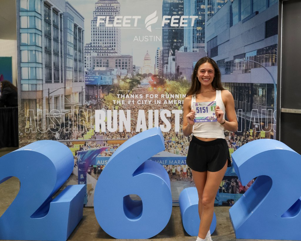 Participant at Fleet Feet backdrop with foam numbers