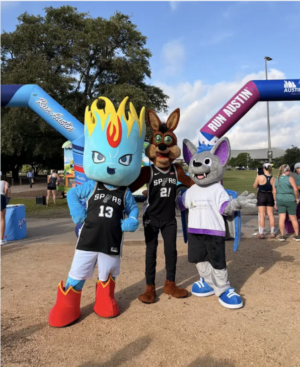Run Austin finish arch with mascots at outdoor race venue