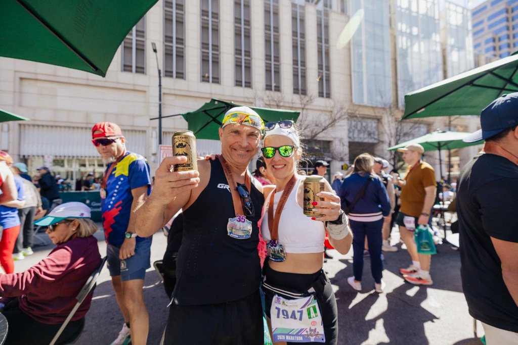 Couple with finisher medals and drinks celebrating