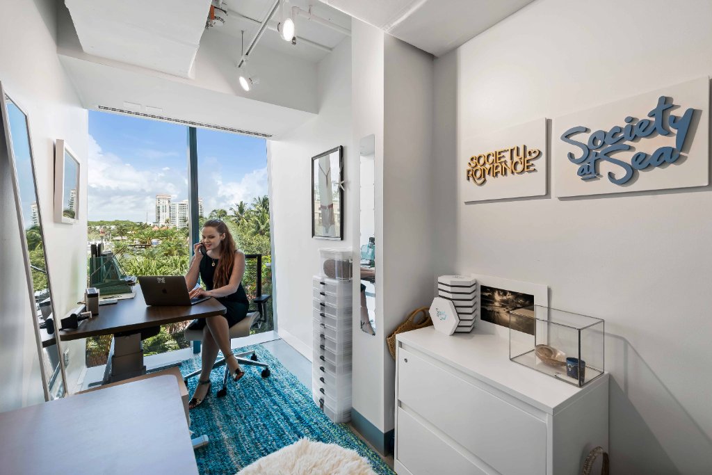 2-Person Office, man + woman, New River view, red chair, art on walls
