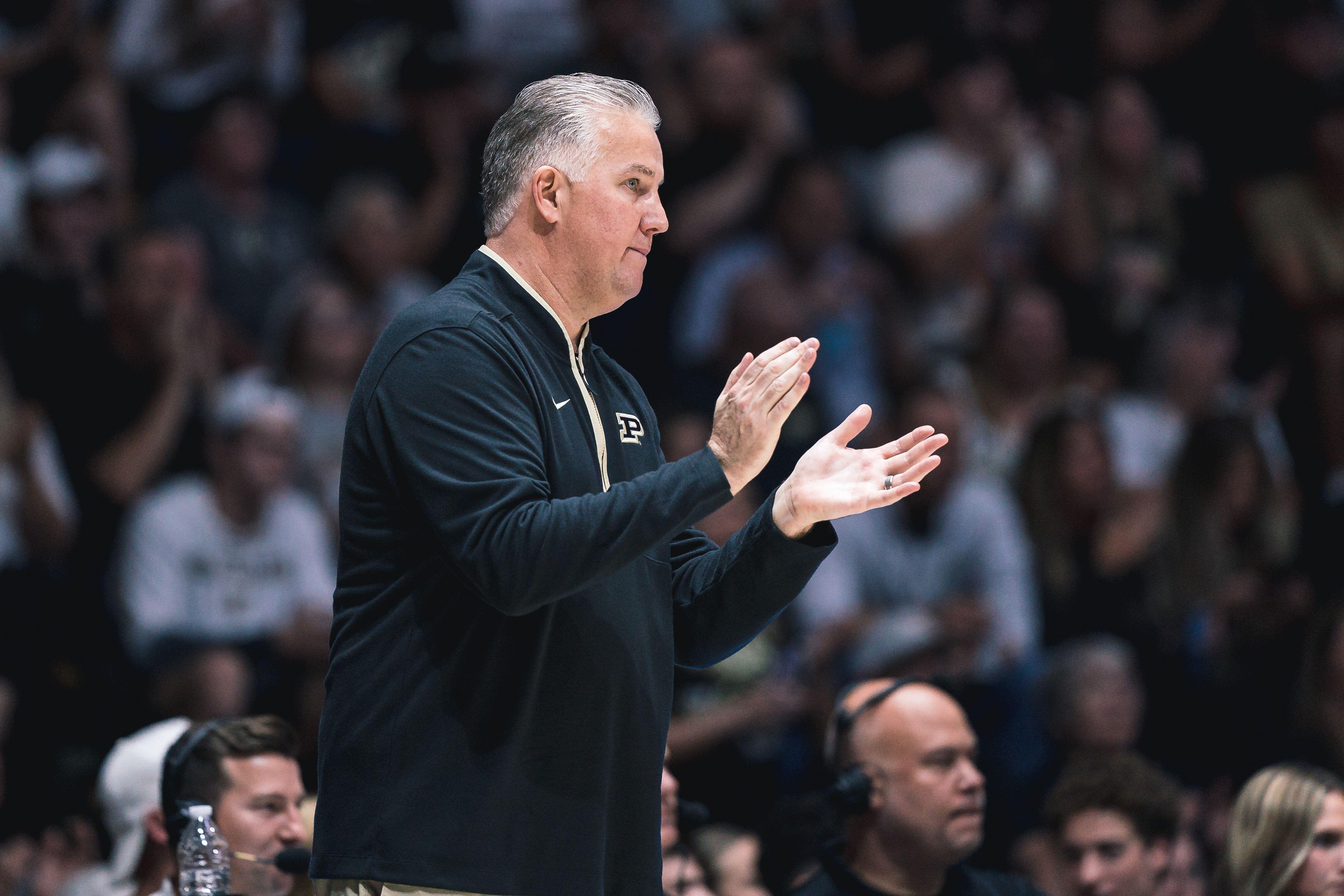Coach clapping on the sideline during a basketball game