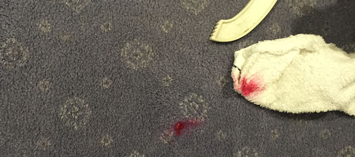 Carpet with red ink stain before professional cleaning