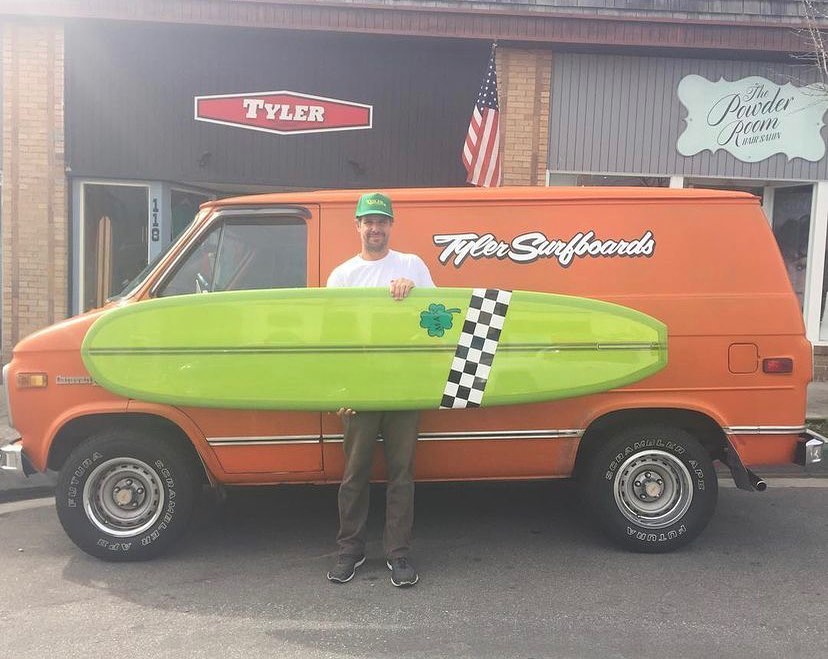 Tyler avec board verte et damier devant le van