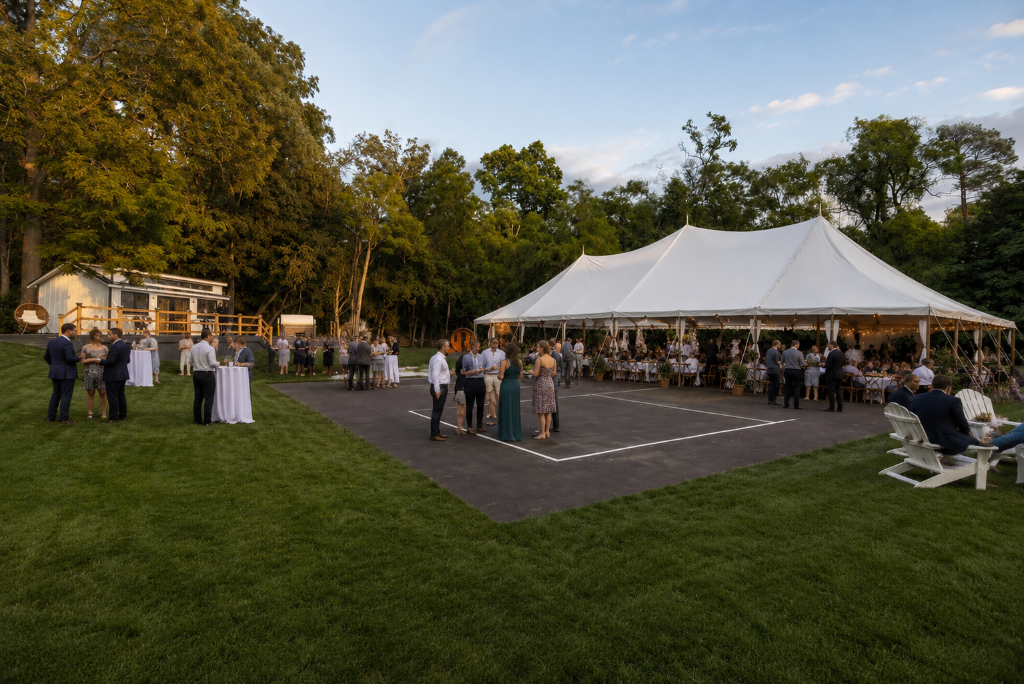 Golden-hour wedding reception under a glowing white tent on the Baladerry Inn lawn
