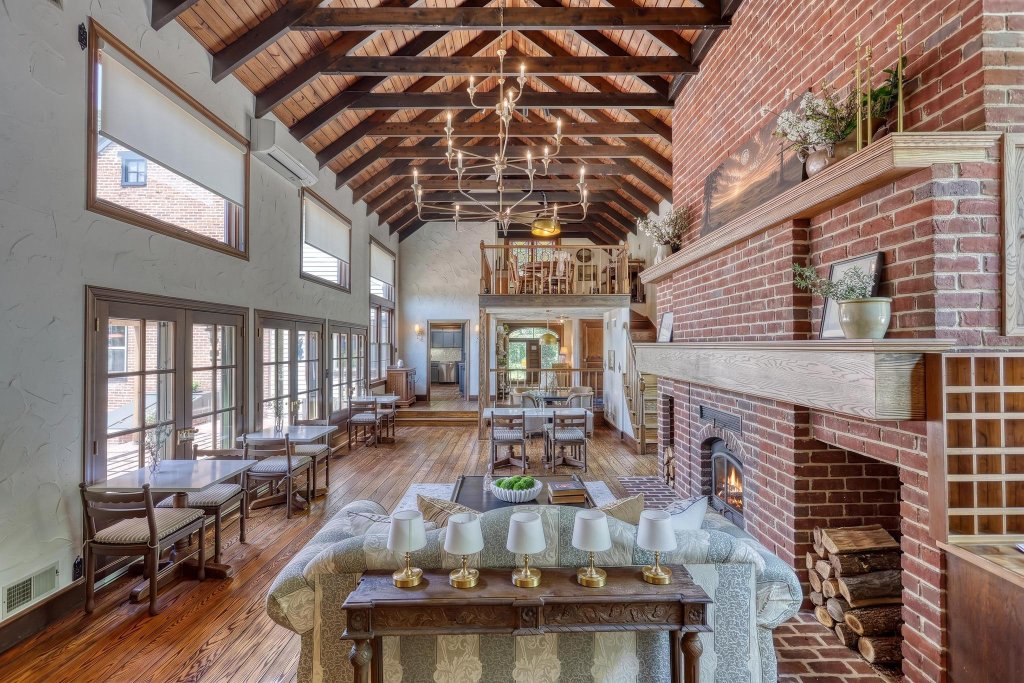 The Great Room with vaulted beamed ceiling, brick fireplace, and inviting seating