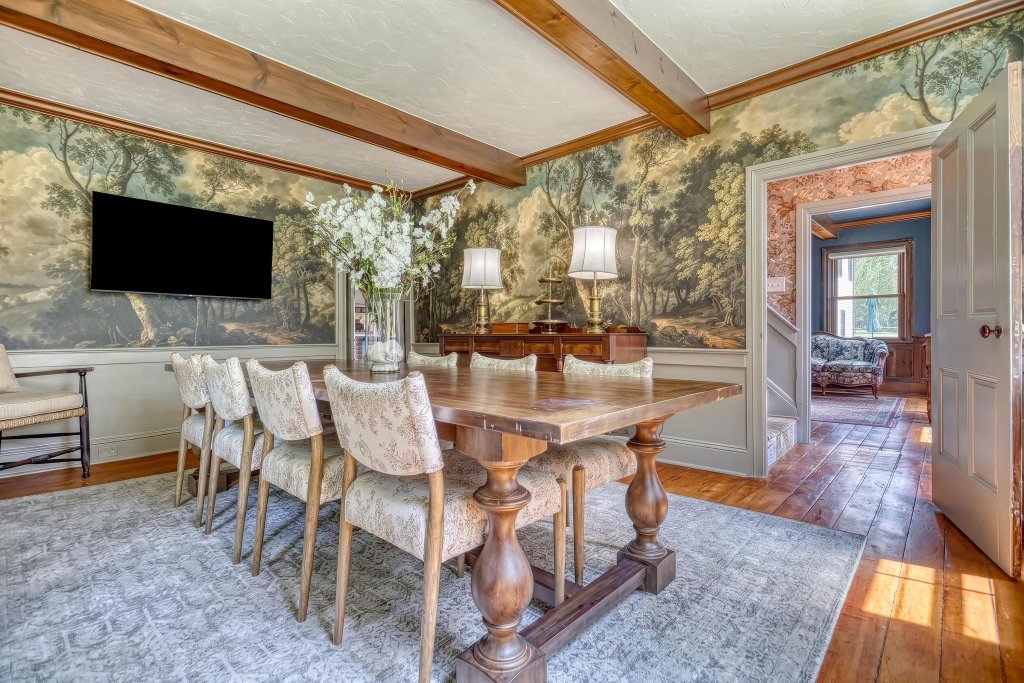 The Buschman Conference Room with dark wood trestle table and scenic mural walls