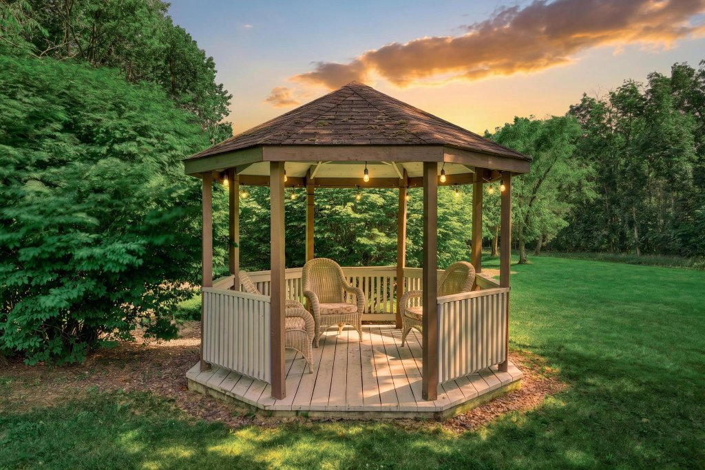 Hexagonal garden gazebo lit with string lights at sunset