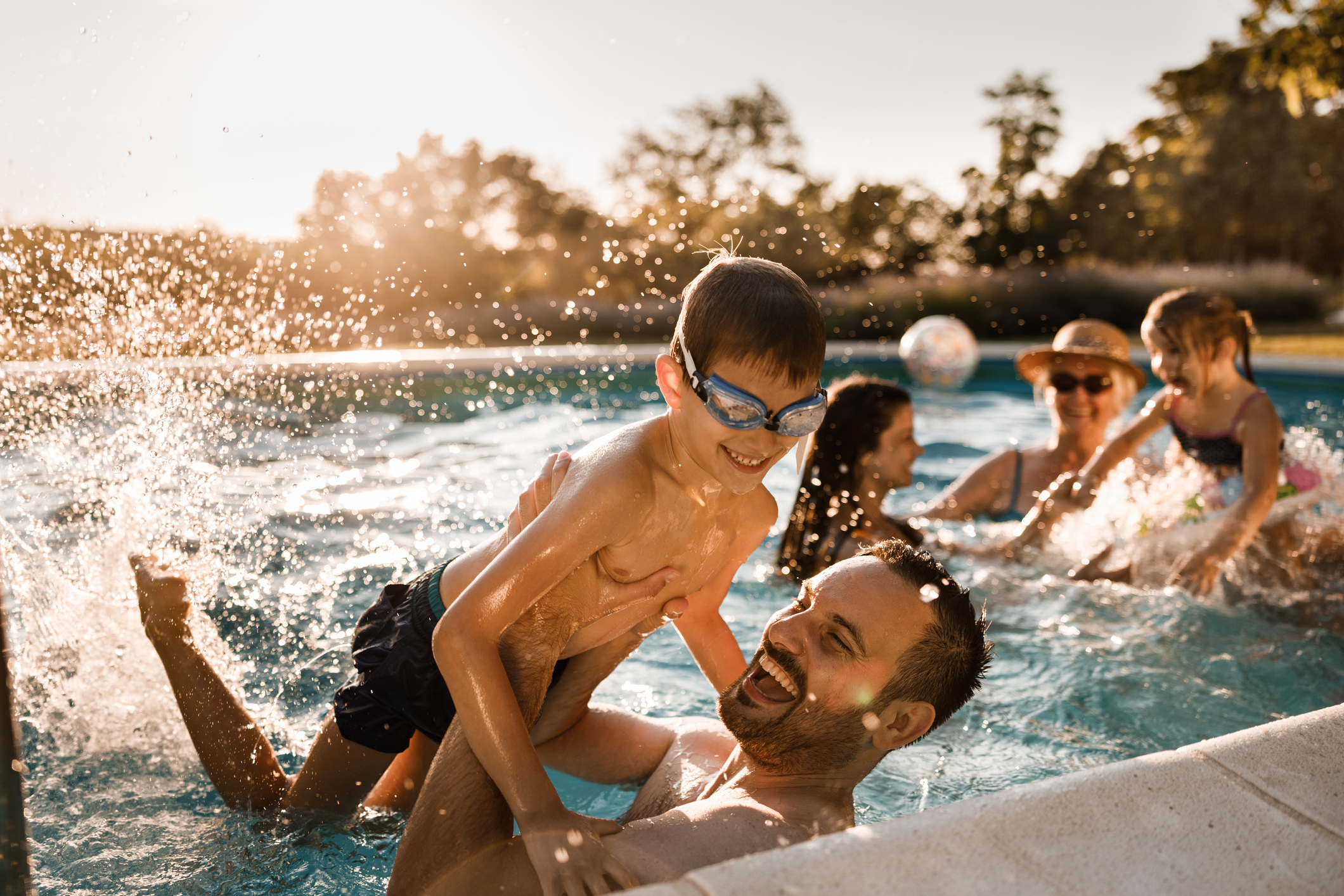 A family splashing and playing together in their new pool at sunset