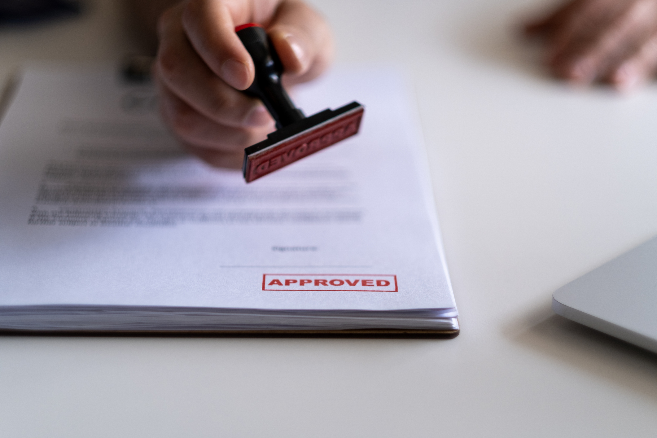 Approved permit documents being stamped at a desk