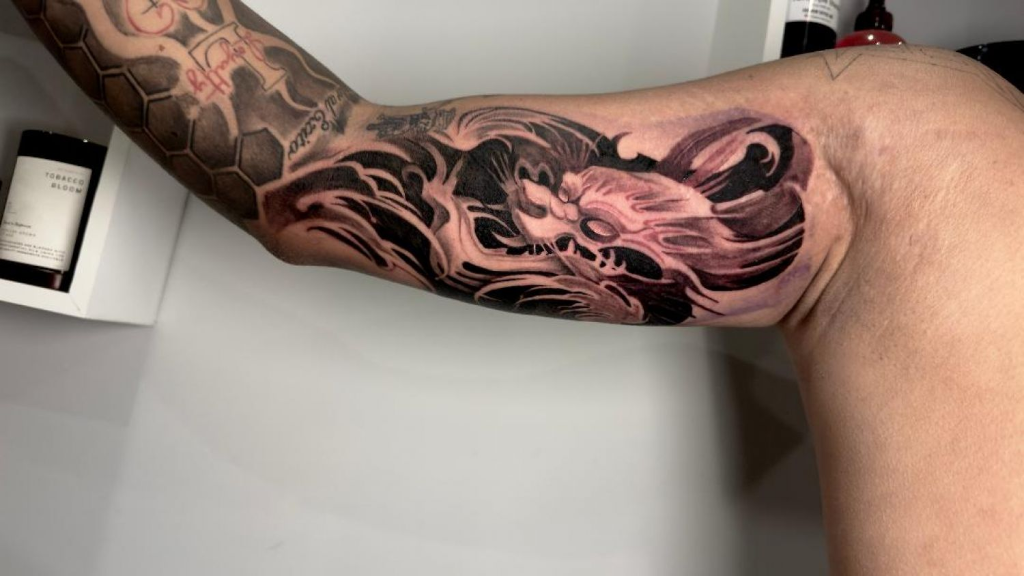 Dragon with flowing water — black & grey realism tattoo by Santiago