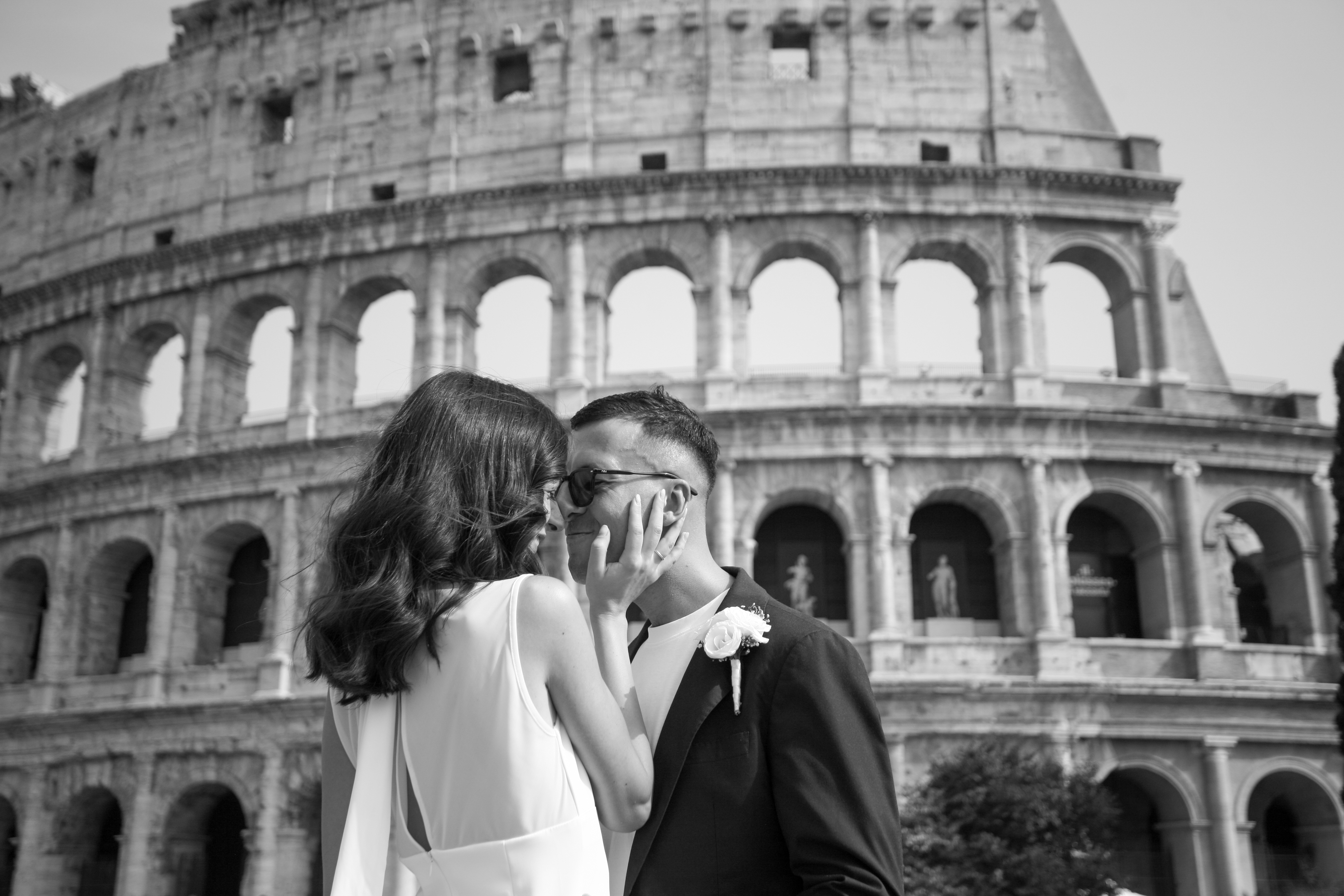 Lei gli sfiora il viso davanti agli archi del Colosseo