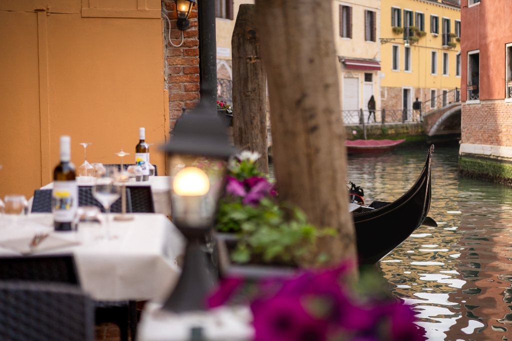 Terrace with purple petunias overlooking the canal