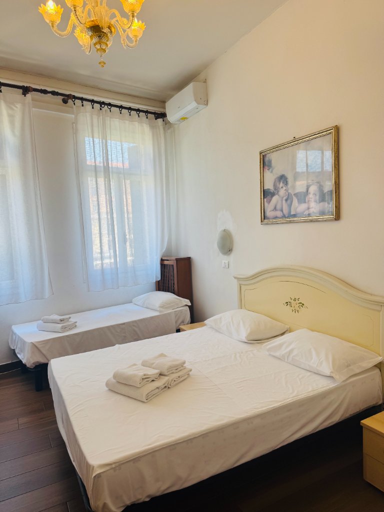 Hotel bedroom with cream headboard, cherub picture and amber chandelier
