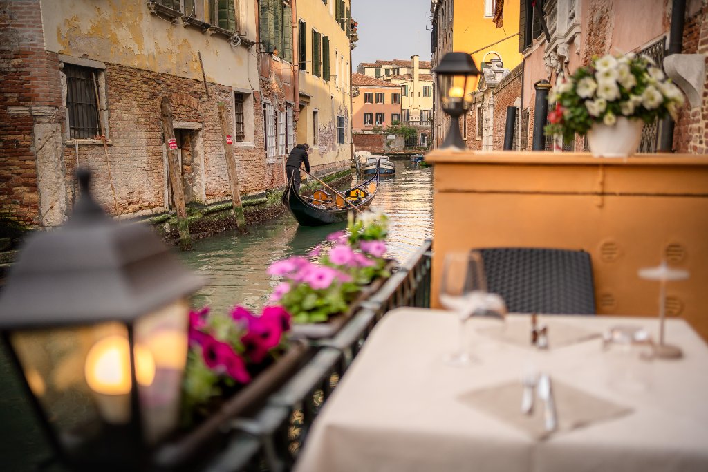 Dining tables along the canal at dusk