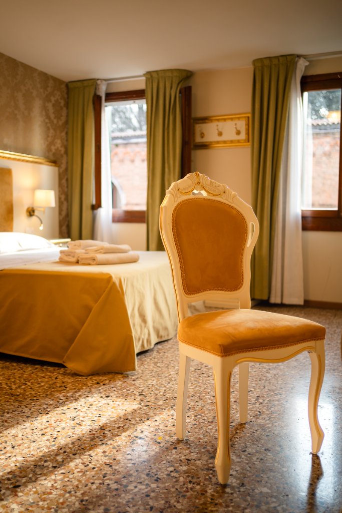 Classic Room with antique chair, gold bedspread and sage curtains