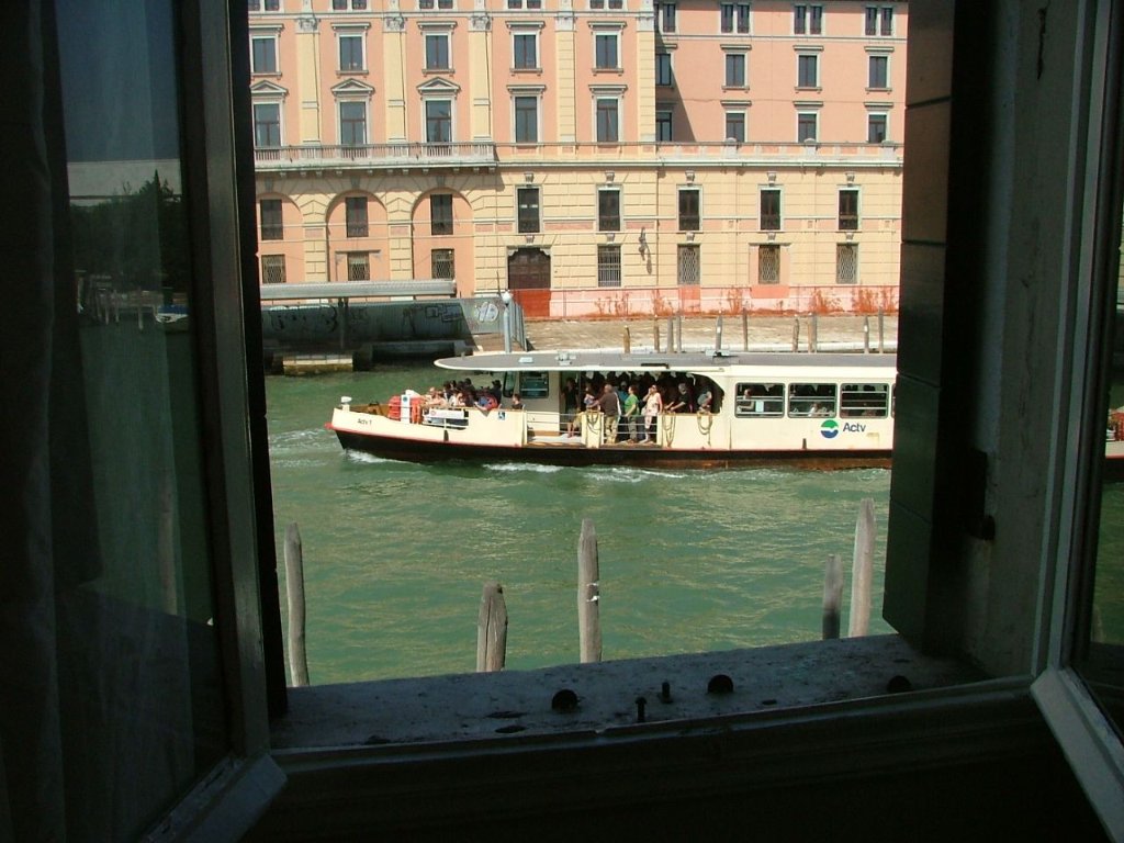 View of a Venetian canal with passing vaporetto, seen from a hotel window