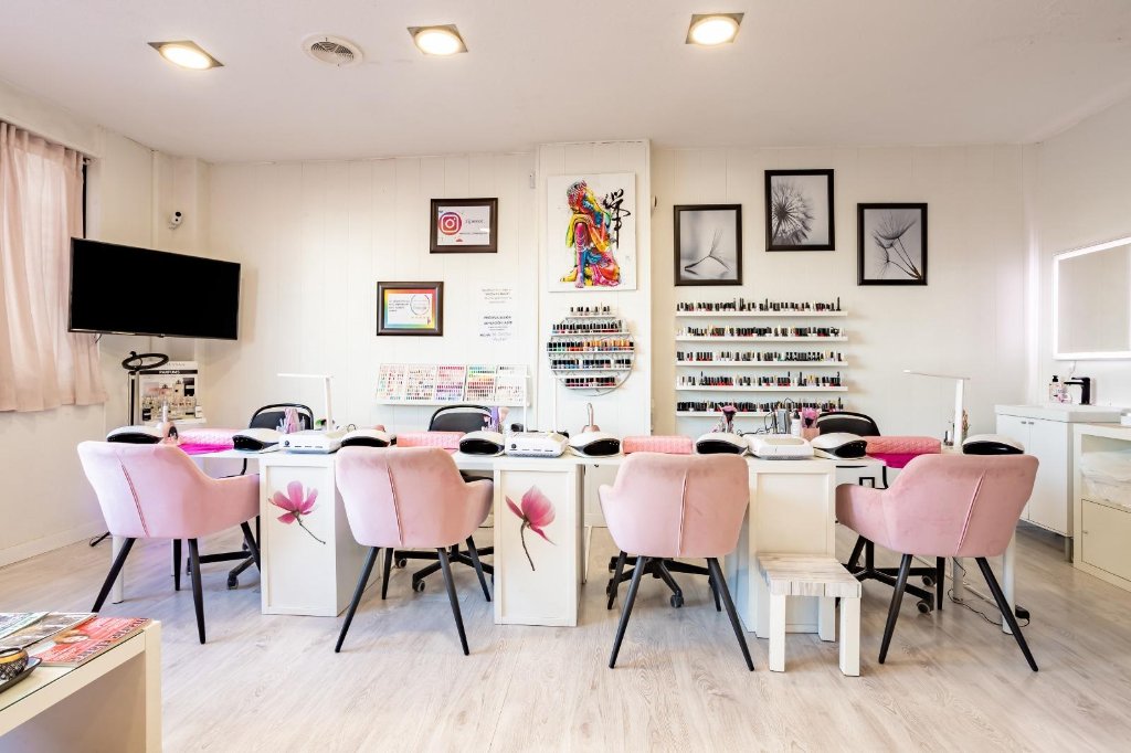 Manos elegantes con manicura minimalista en tonos rosa sobre tela de seda