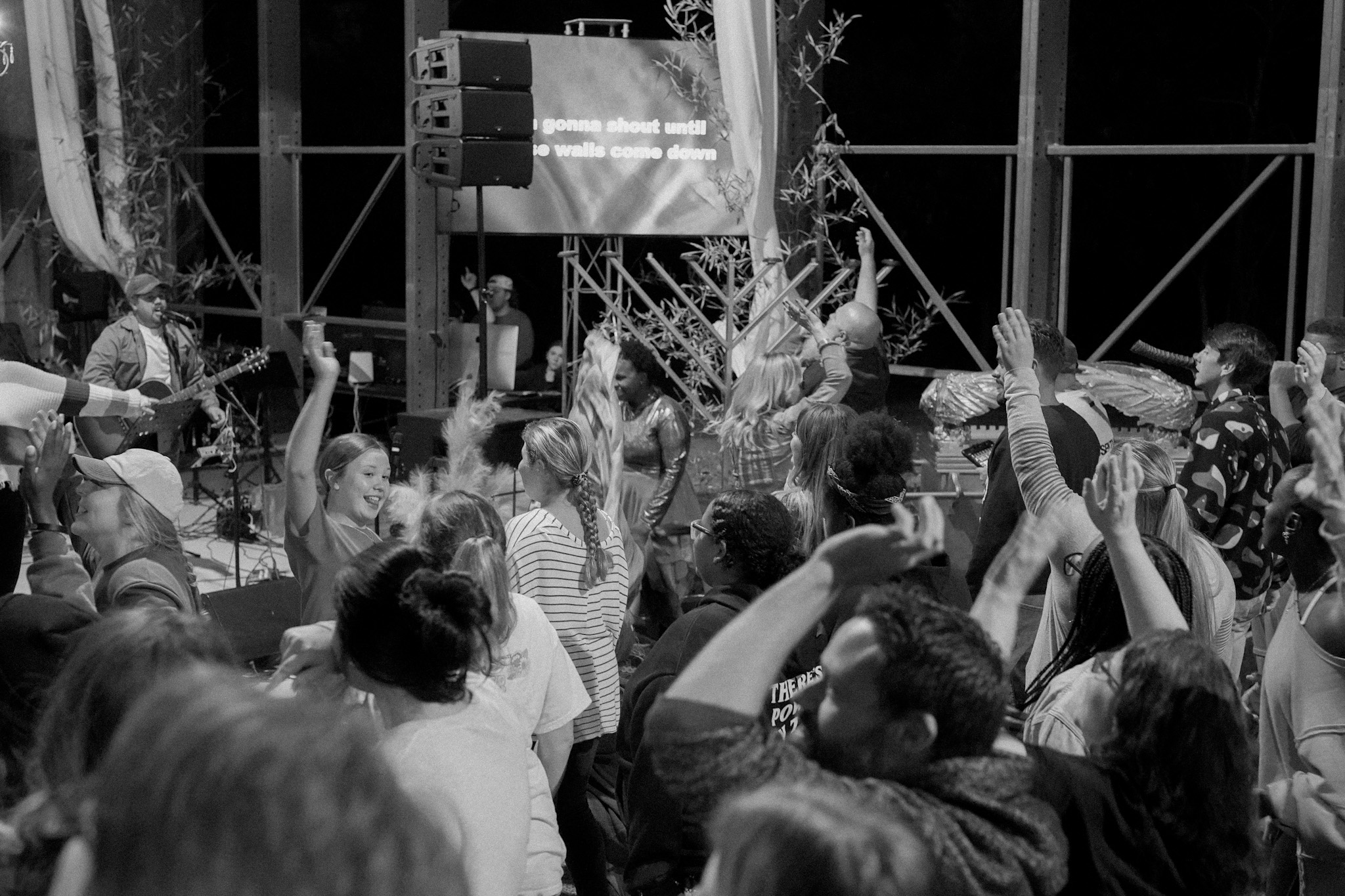 Hands raised in worship during a House Group gathering