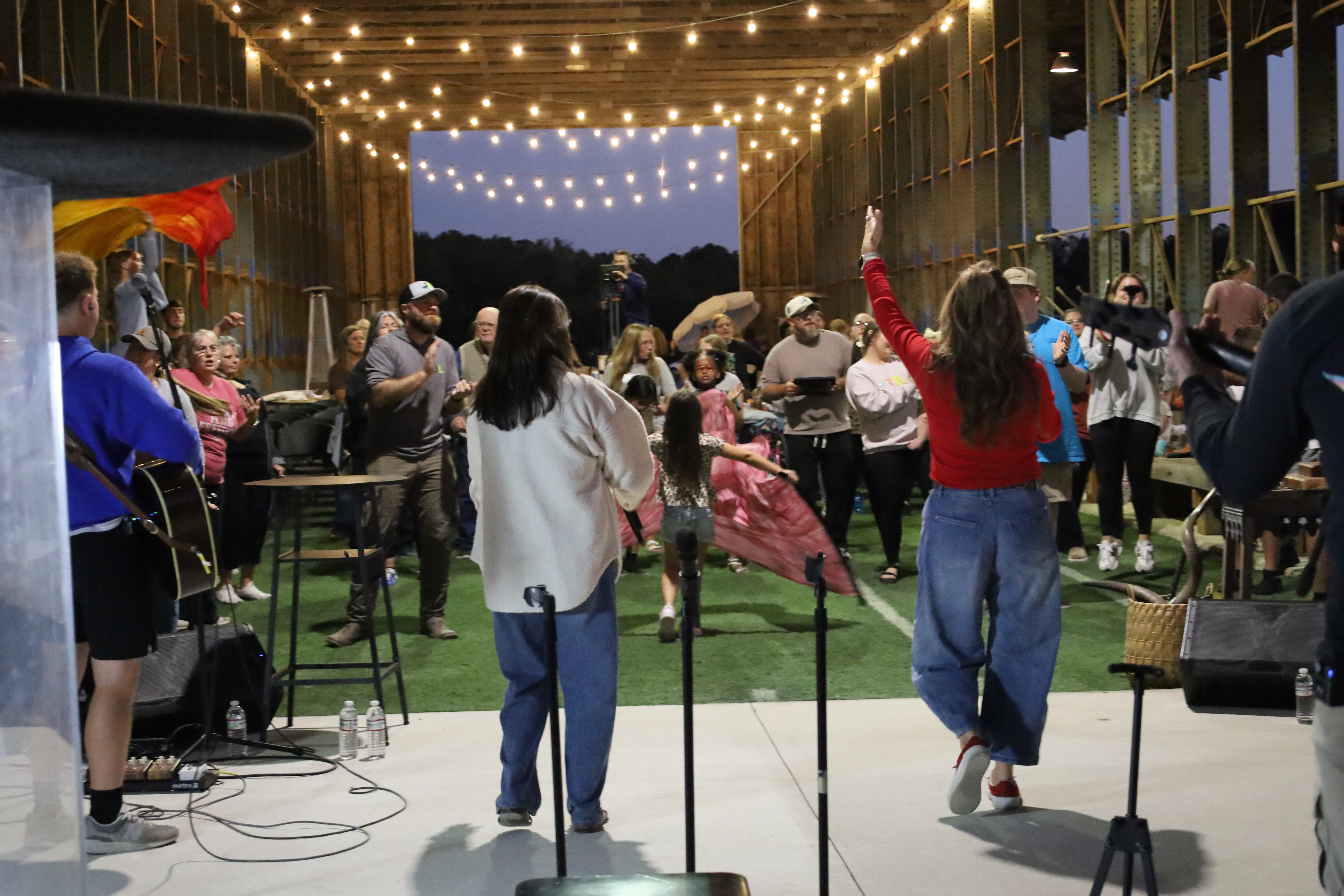 Worship under string lights at twilight