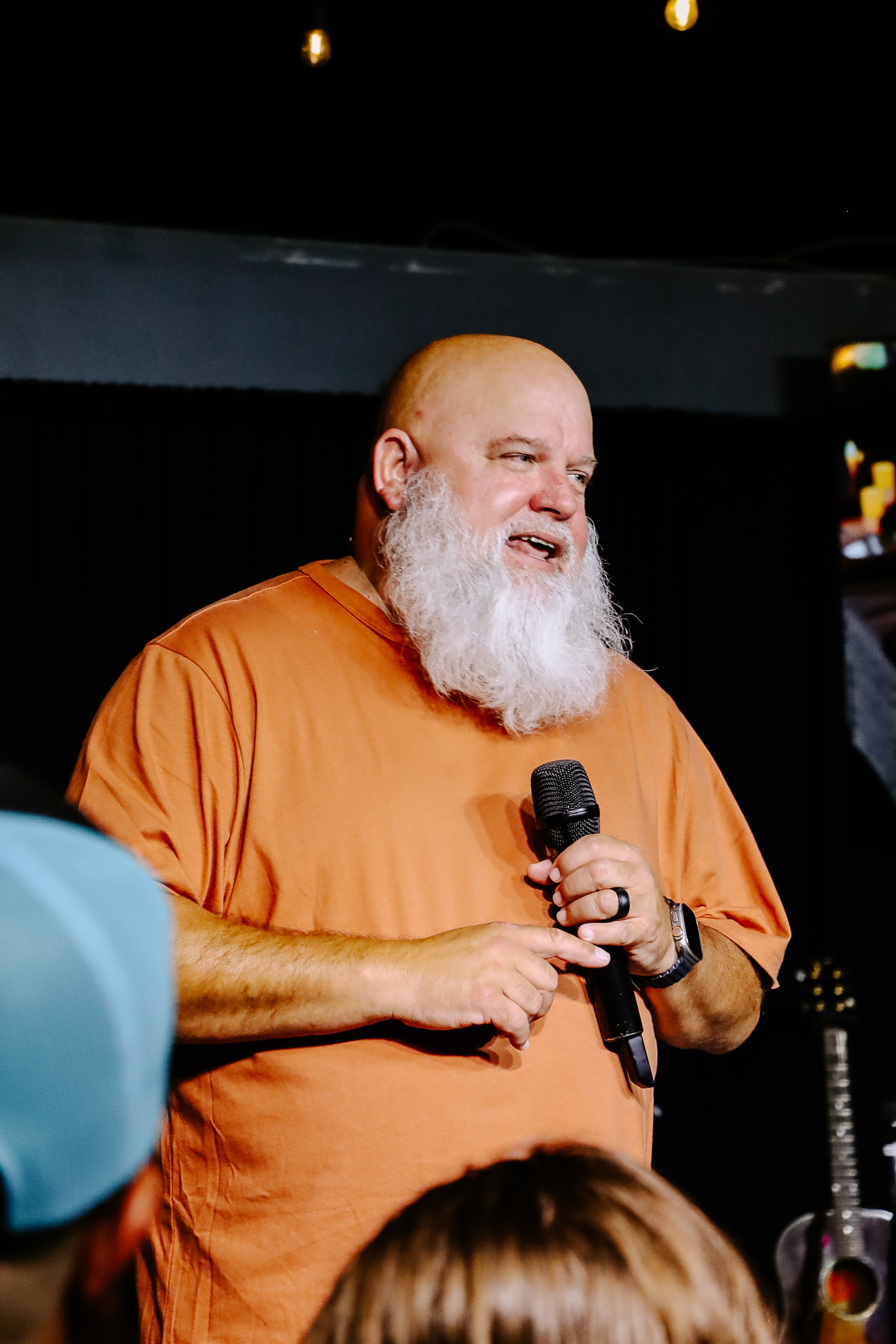 A man speaking into a microphone at a gathering