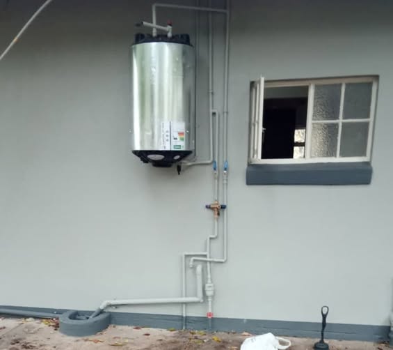 Vertical water heater installation with valve manifold
