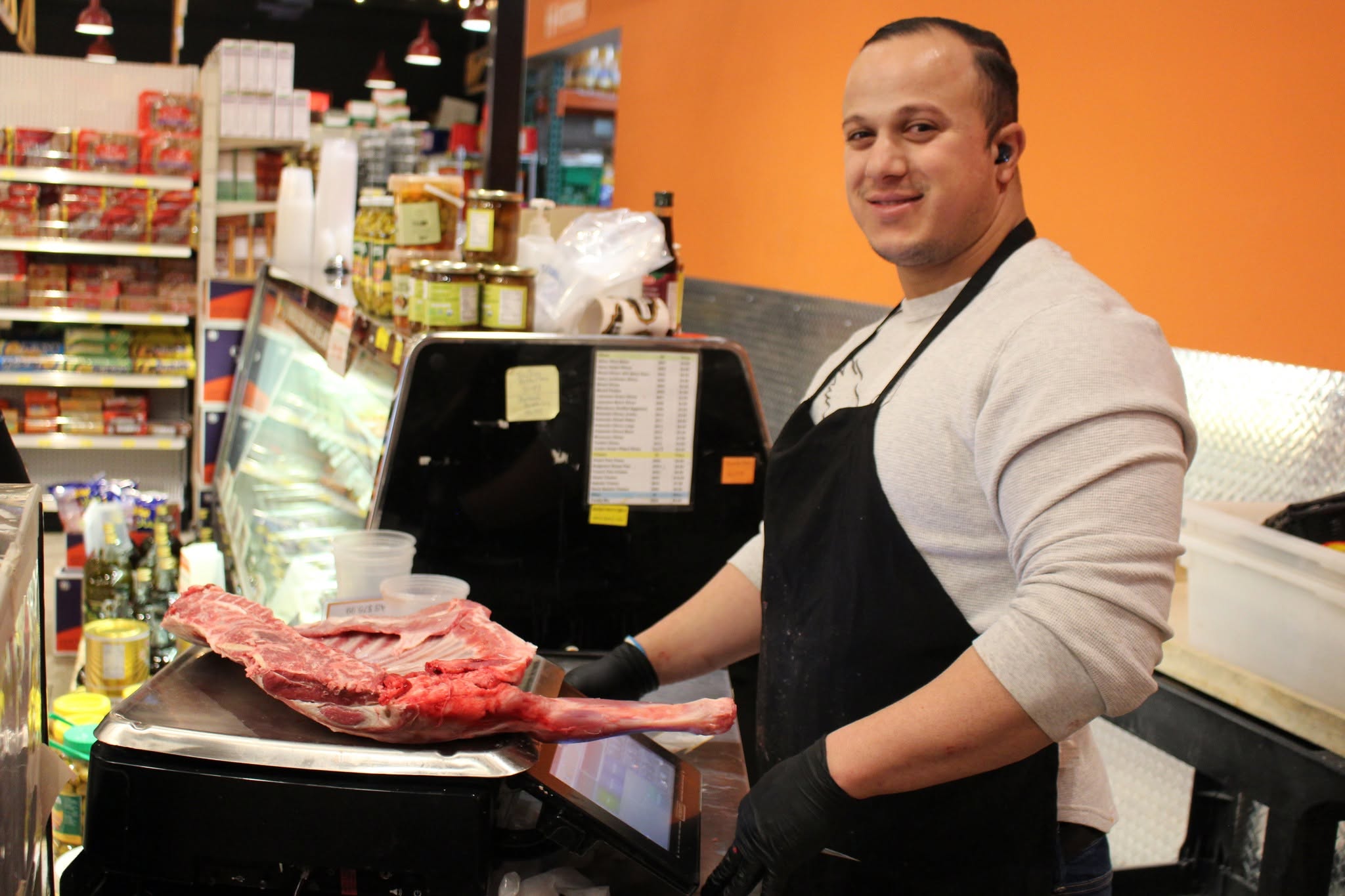 Meat department team member weighing a fresh cut