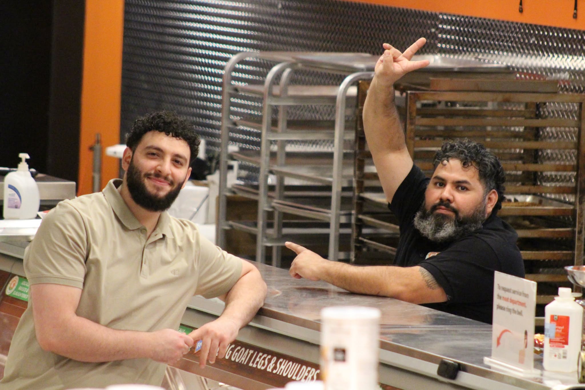 Two Pangea team members behind the meat counter