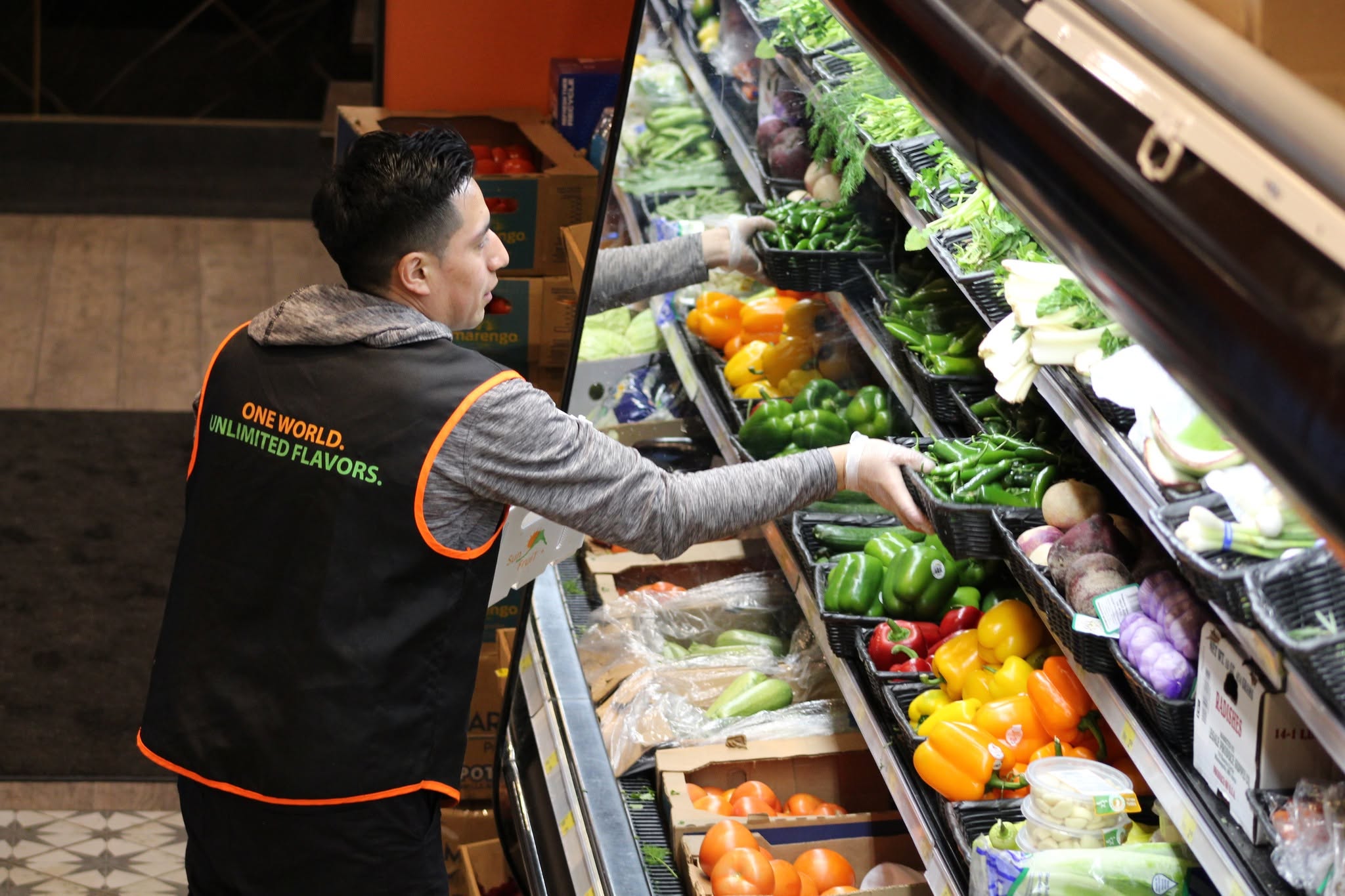 Pangea employee stocking the fresh produce display