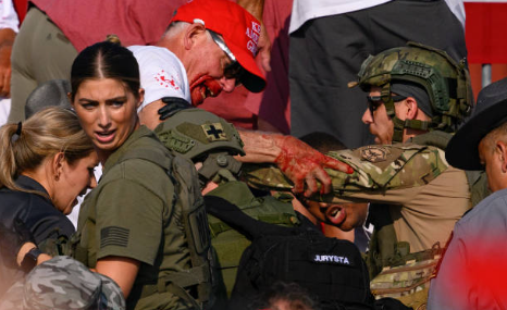 Shooting victim covered in blood being assisted by law enforcement in stands Butler Pennsylvania July 13 2024