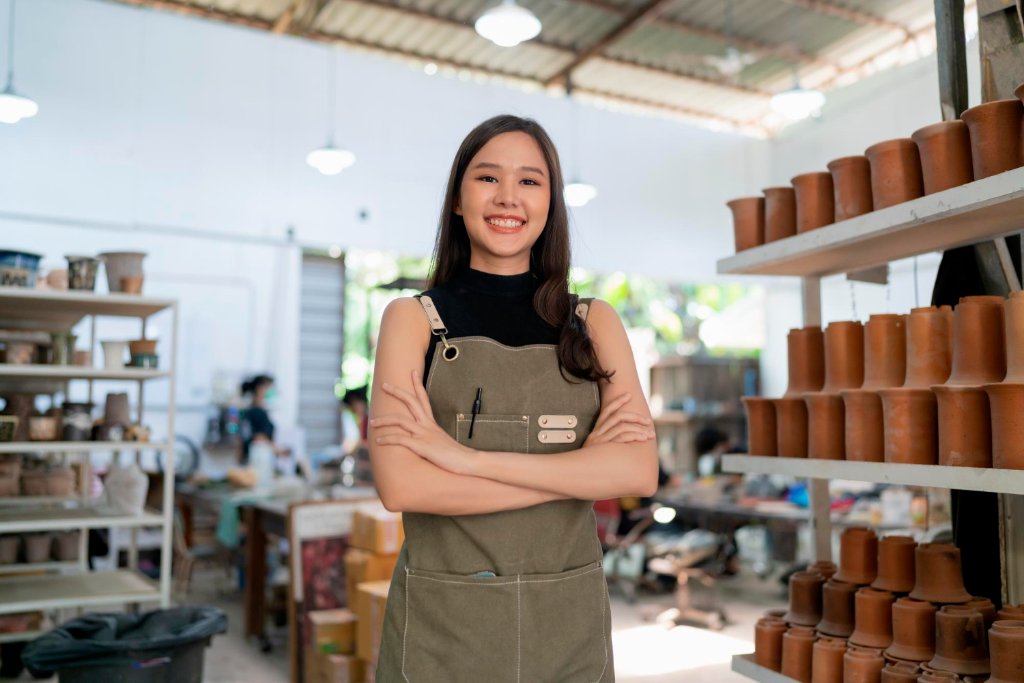Empreendedora sorrindo em seu ateliê