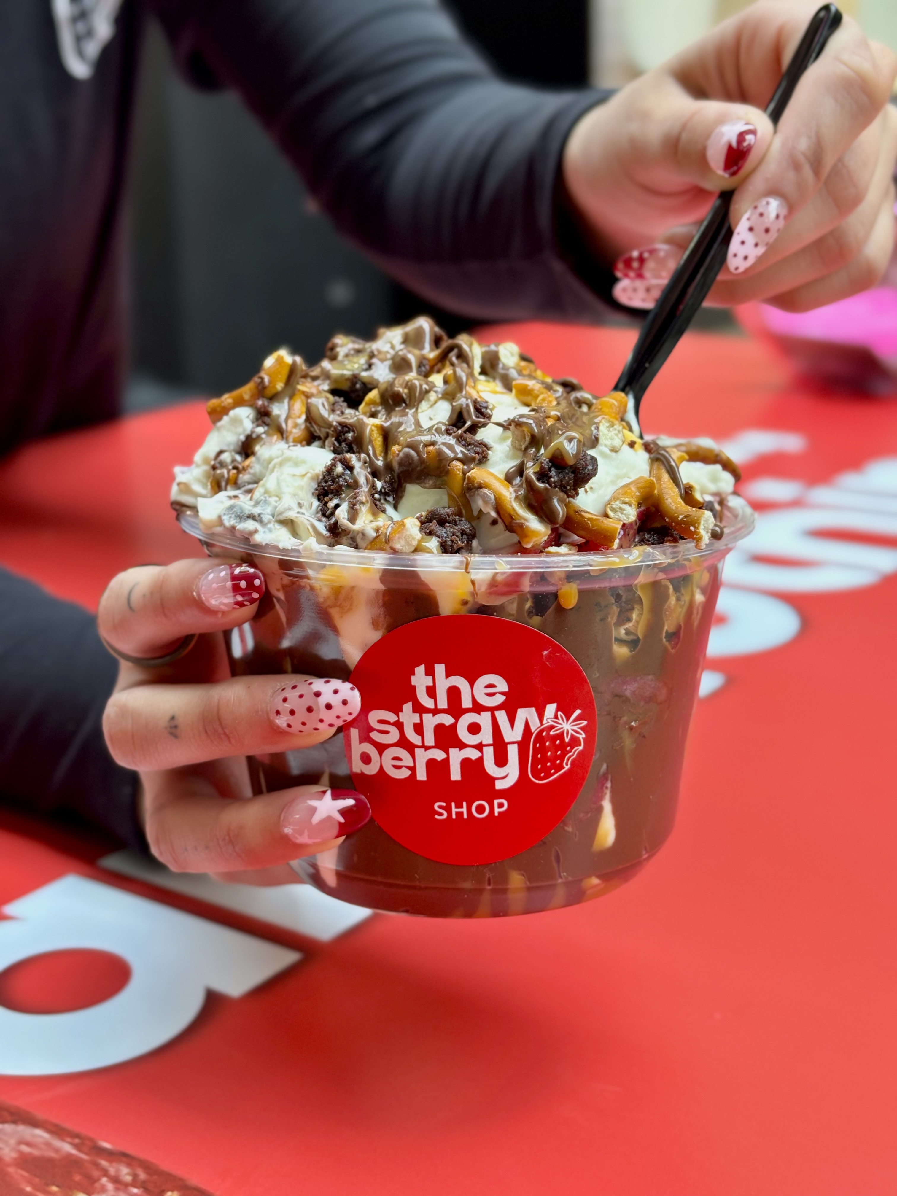 Customer holding a Strawberry Shop dessert cup