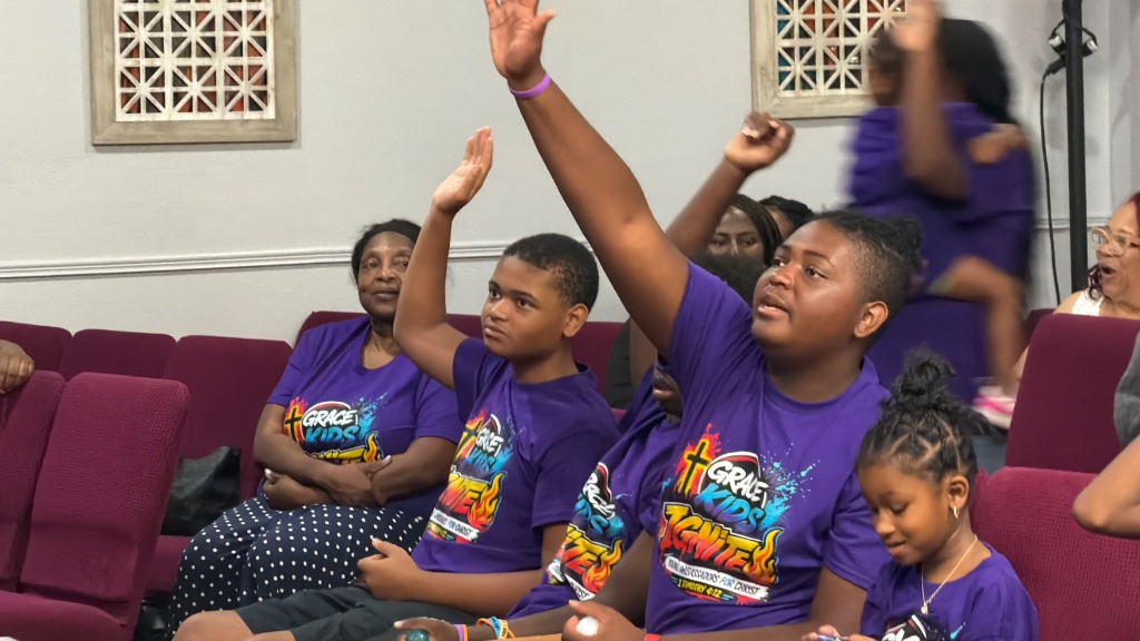 Kids raising hands in worship at IGNITE VBS