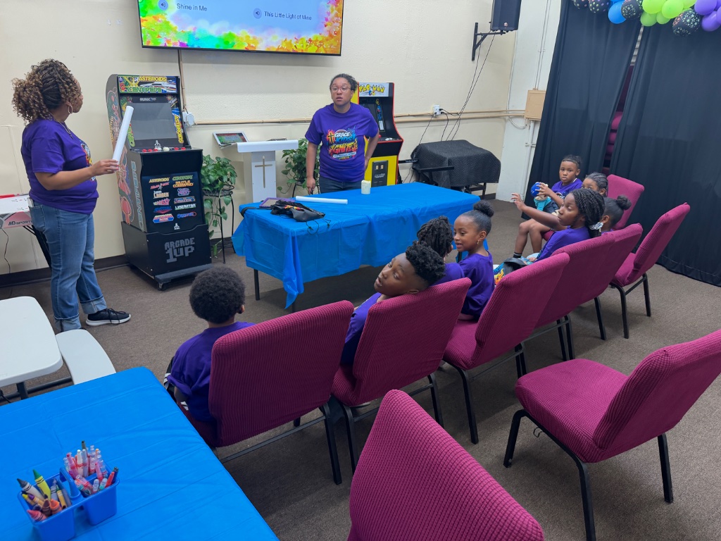 Leader holding curriculum booklet at IGNITE VBS