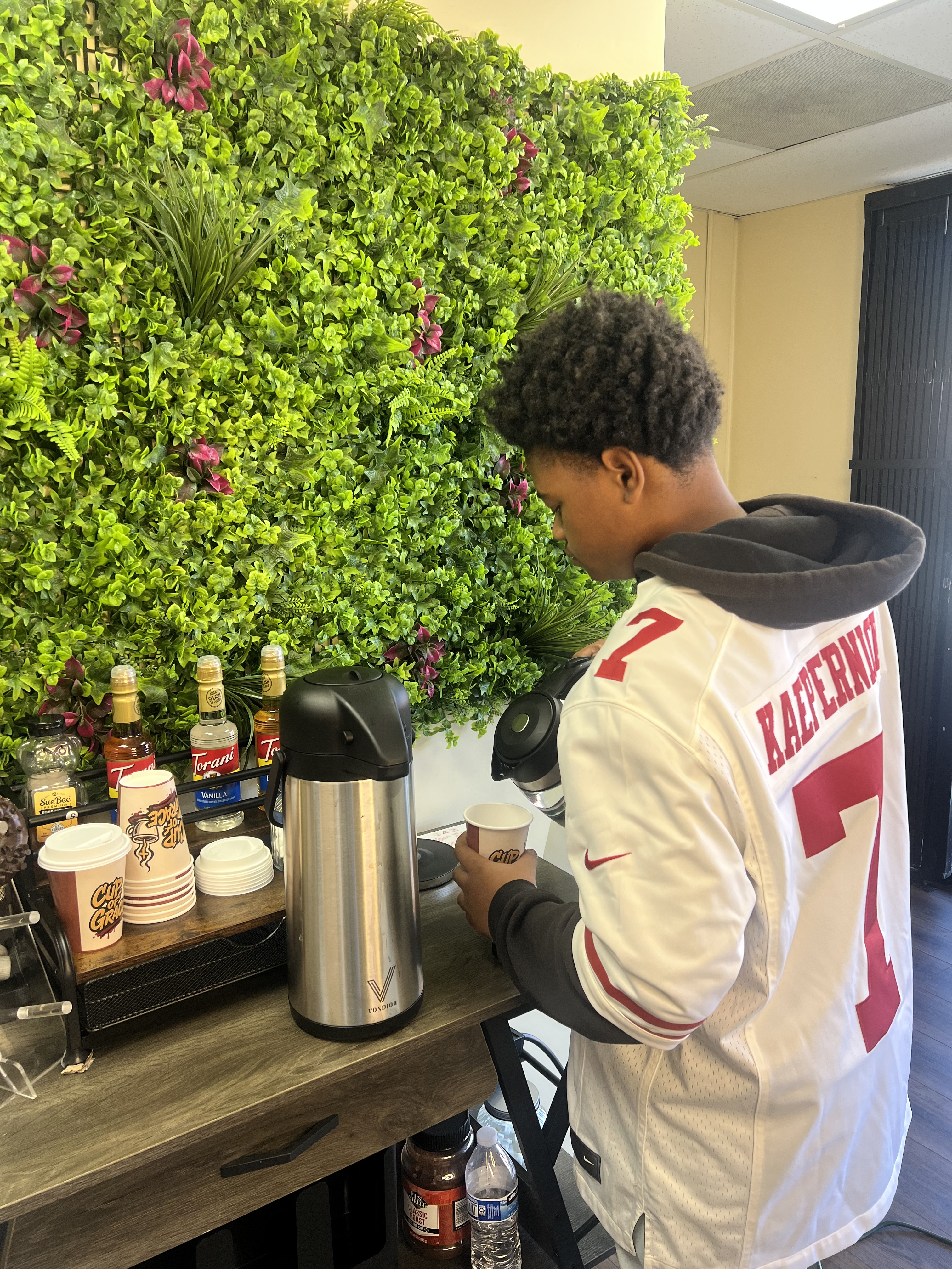 Pouring a fresh cup of Cup of Grace coffee at the café station