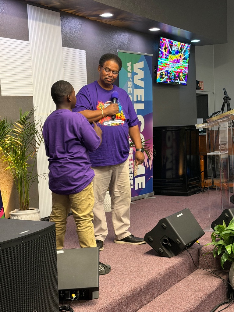 Pastor with child on stage at IGNITE VBS