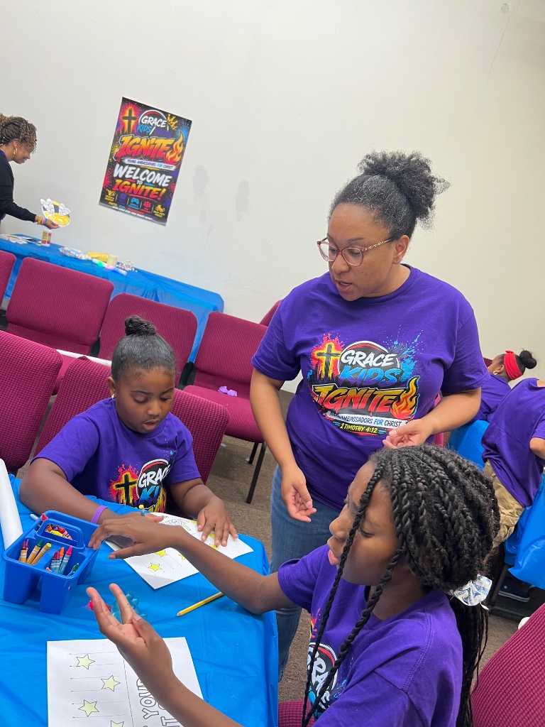 Leader helping child with craft at IGNITE VBS