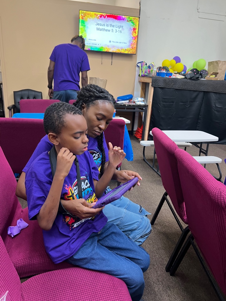 Child and leader looking at tablet together