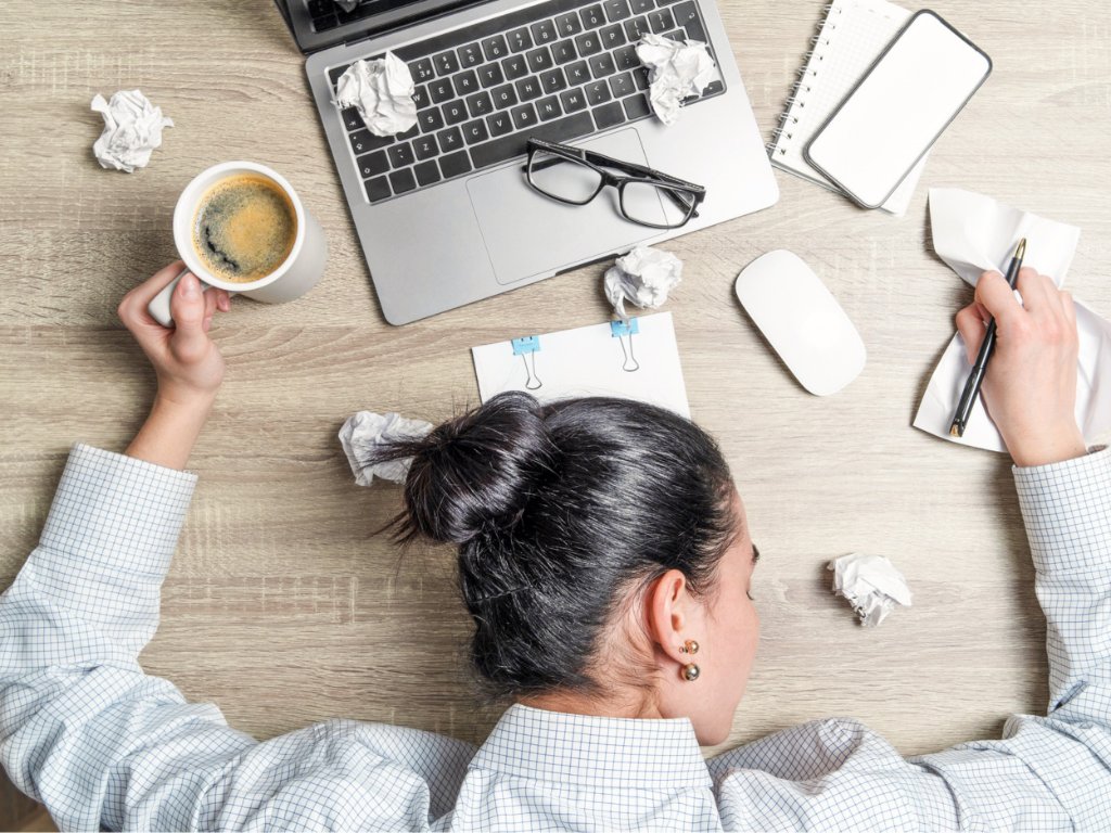 Writer experiencing writer's block at a cluttered desk