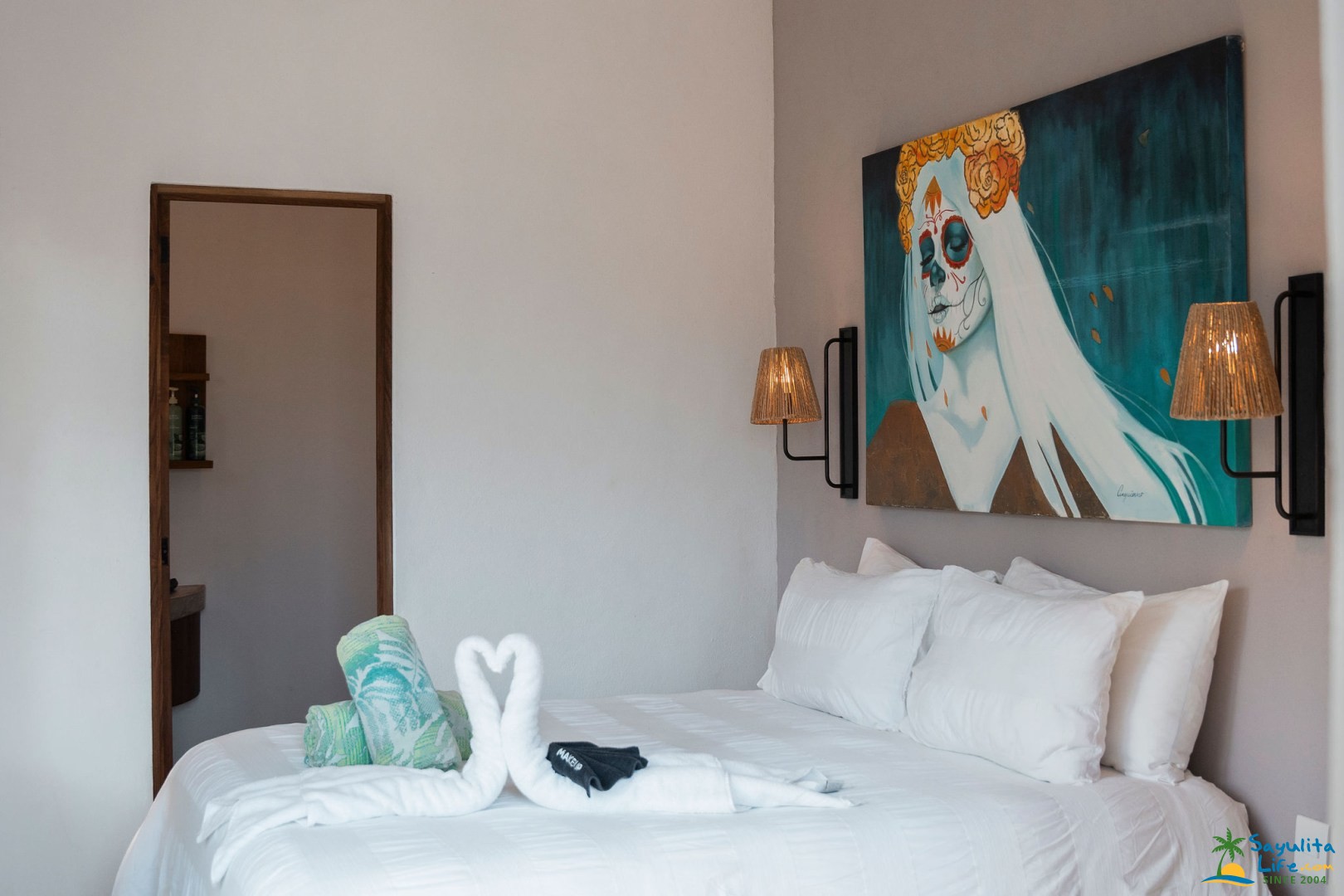 Bedroom with Catrina art and swan-folded towels