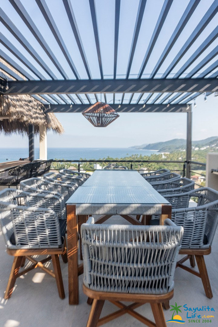 Outdoor dining table under pergola with ocean view