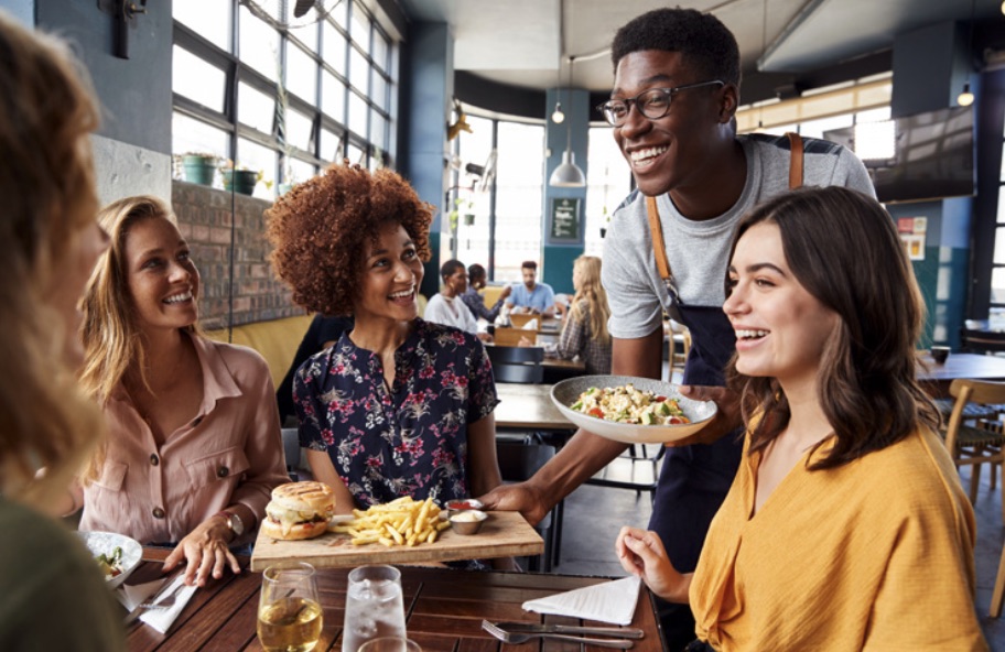 Friends dining at a lively boardwalk restaurant