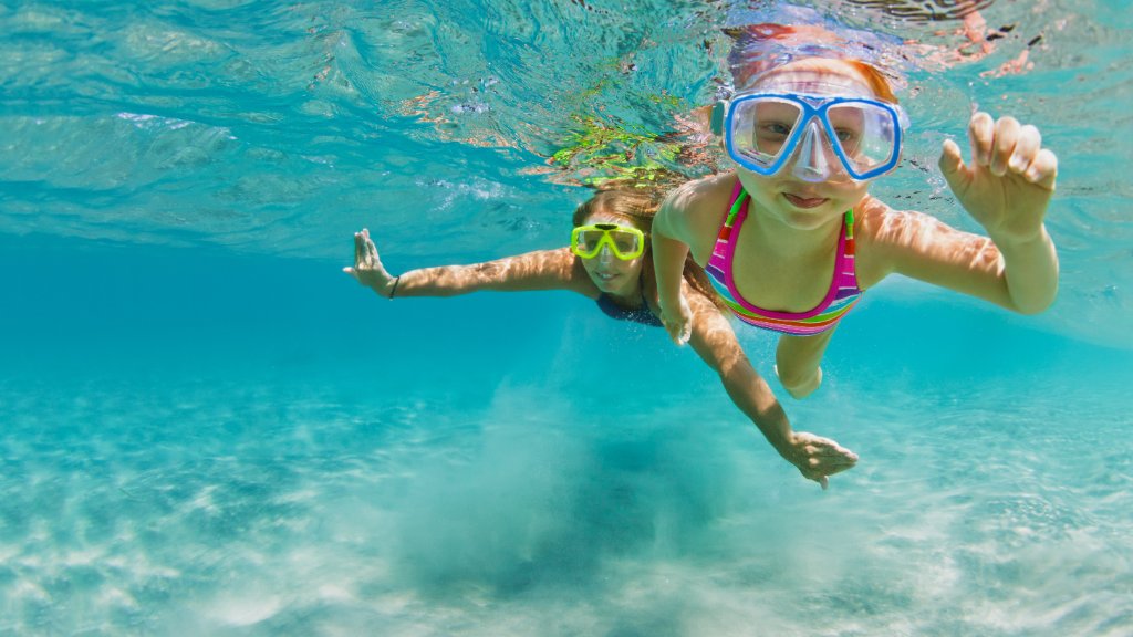 Children snorkeling underwater in crystal clear lagoon